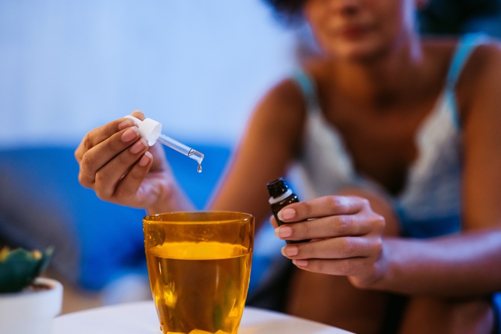 woman dropping cbd into water