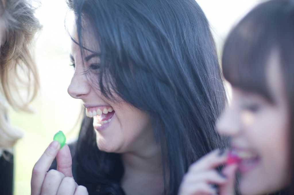 Cannabis edibles for beginners: Photo of people close-up laughing and eating candy.