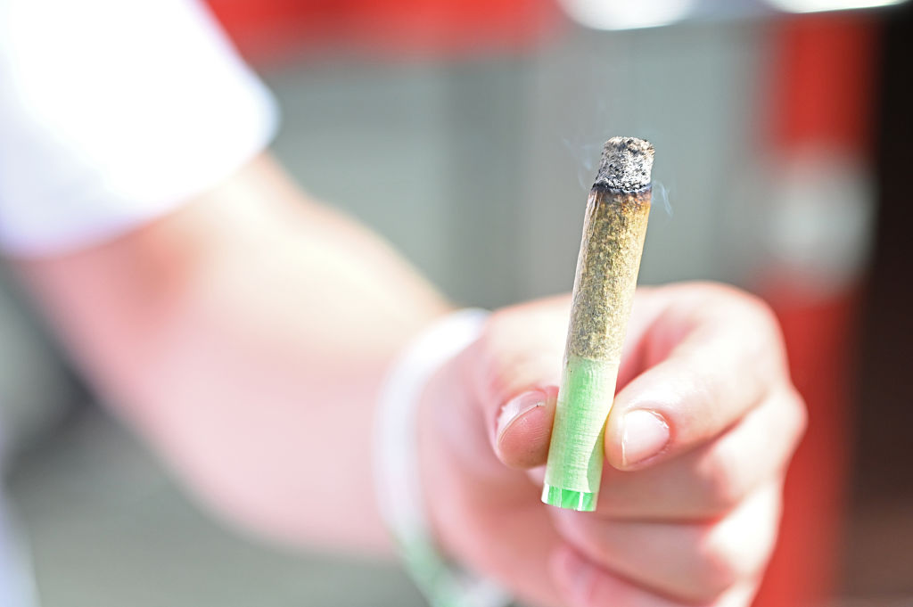 A man holds a joint at the edge of the Mary Jane cannabis fair. Study shows cannabis may help migraines