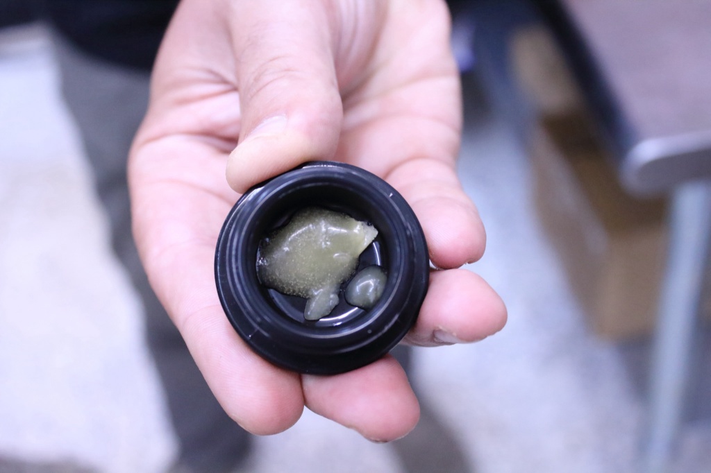 hand holding jar of harvest hash