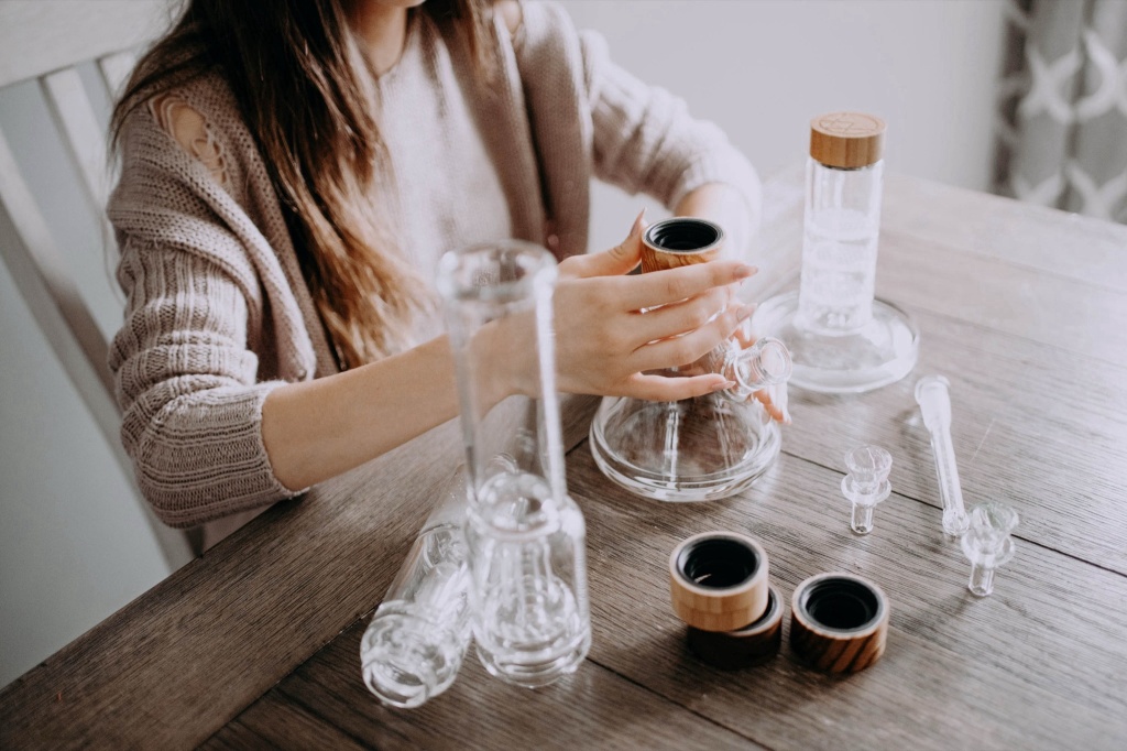 woman with variety of Vitae Glass custom bong pieces