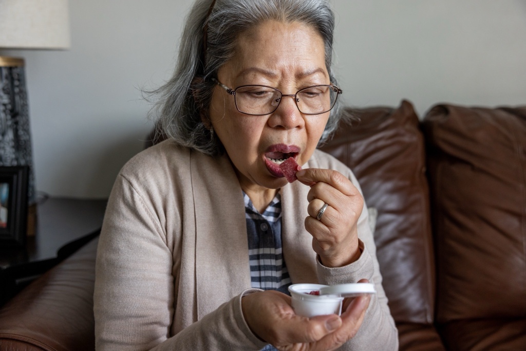 woman eats gummy medical cannabis for seniors