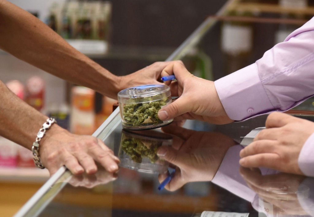 hand holding jar of marijuana in the cannabis user experience