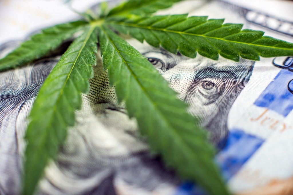 cannabis leaf over currency representing raising capital in cannabis