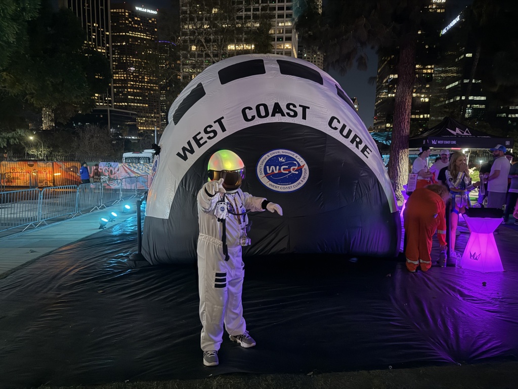person dressed as astronaut on front of West Coast Cure rocket